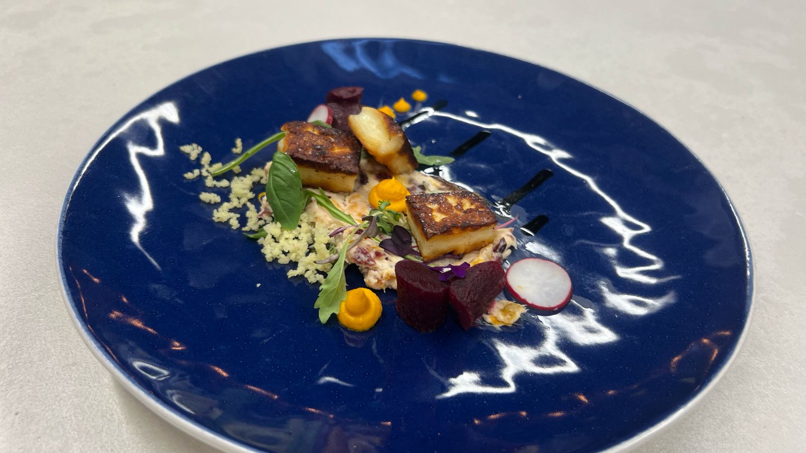 Pan-seared halloumi on blue plate